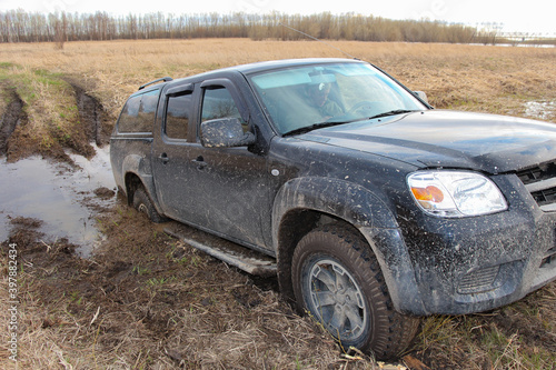 The black car got stuck in the mud. Off-road driving.