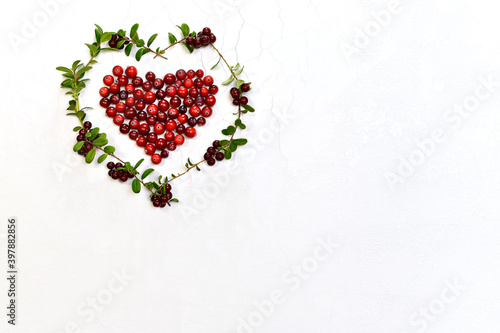 Foto The heart is lined with cranberries, wreath of lingonberry with berries and leaves