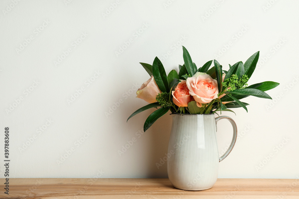 Bouquet of beautiful flowers in vase on wooden table against white background. Space for text