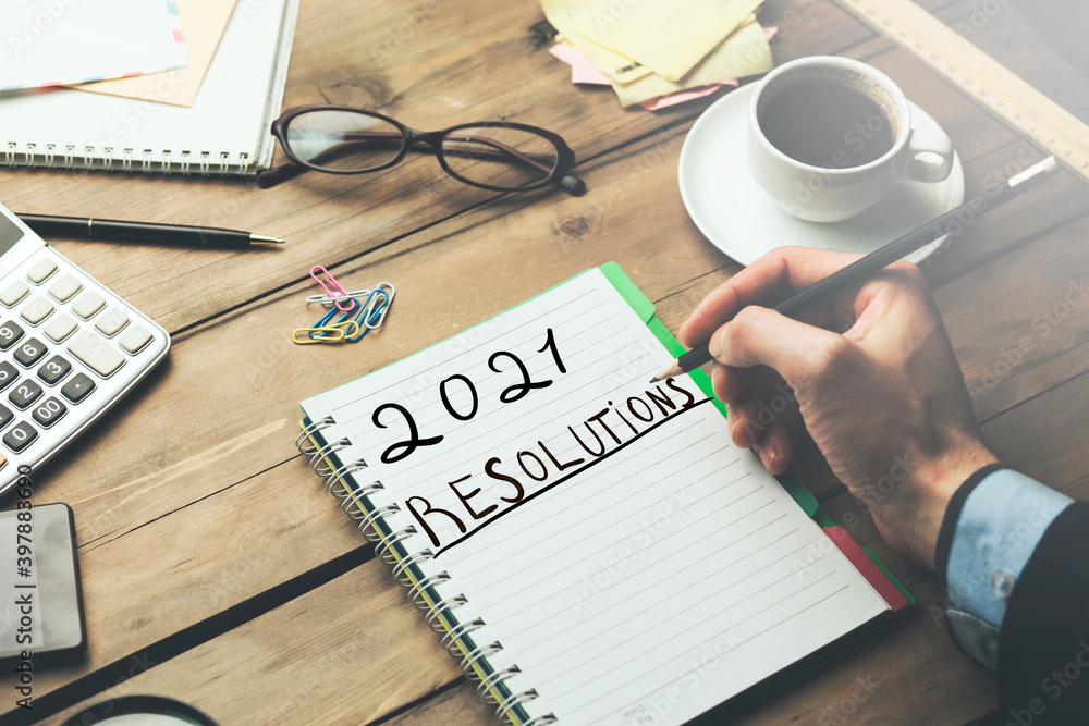 man and 2021 resolutions on working desk man and 2021 resolutions on working desk