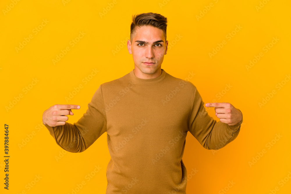 Young handsome caucasian man isolated person pointing by hand to a shirt copy space, proud and confident Young handsome caucasian man isolated person pointing by hand to a shirt copy space, proud and confident