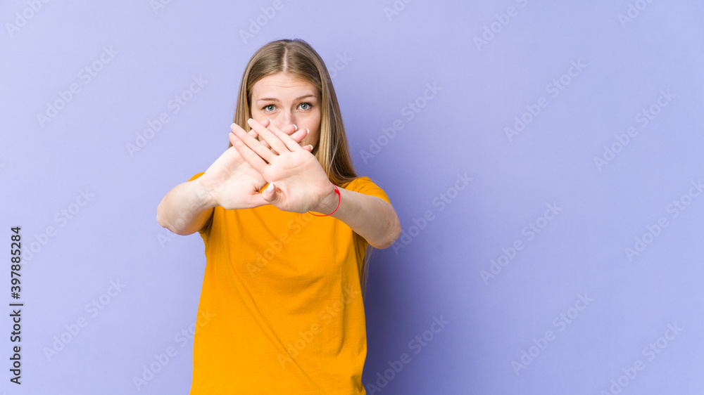 Young blonde woman isolated on purple background doing a denial gesture Young blonde woman isolated on purple background doing a denial gesture