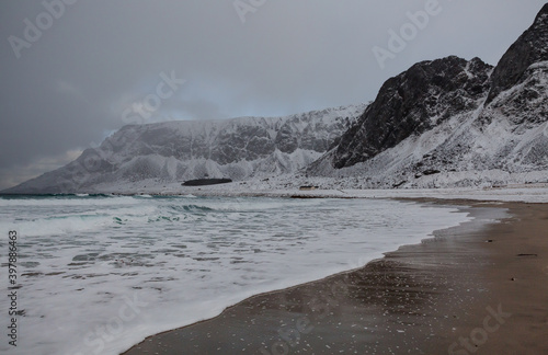 snow covered mountains at the Unstad beach in the Lofoten archipelago, Norway photo