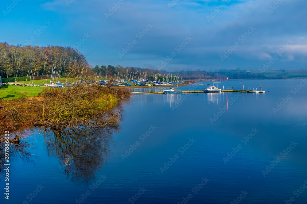A view of boats moored up for winter on the shoreline of Pitsford Reservoir, UK