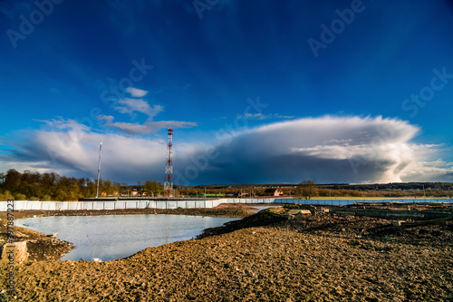 farm pond and cumulonimbus clouds in the evening