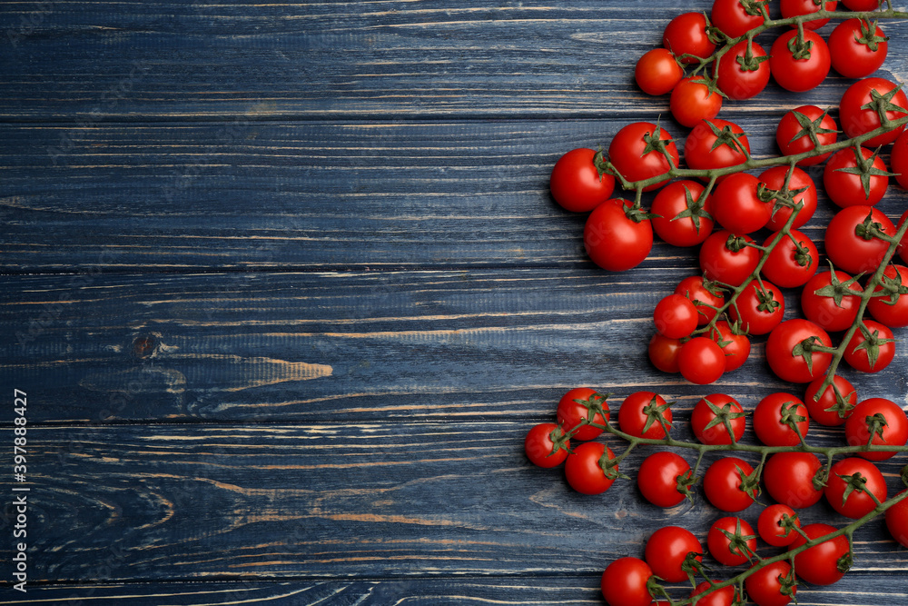 Fresh ripe cherry tomatoes on blue wooden table, flat lay. Space for text Fresh ripe cherry tomatoes on blue wooden table, flat lay. Space for text