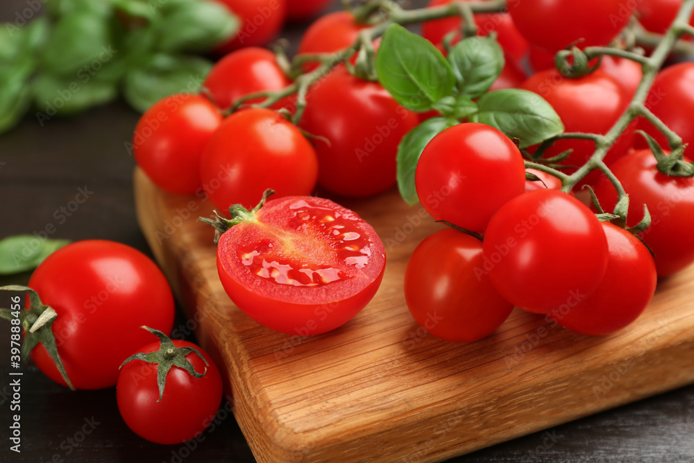 Fresh cherry tomatoes and basil on wooden table, closeup Fresh cherry tomatoes and basil on wooden table, closeup