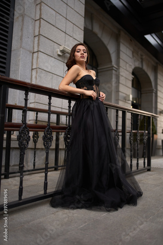 Full-length portrait of an elegant brunette woman with long hair in a black long evening dress. © Владимир Николаев
