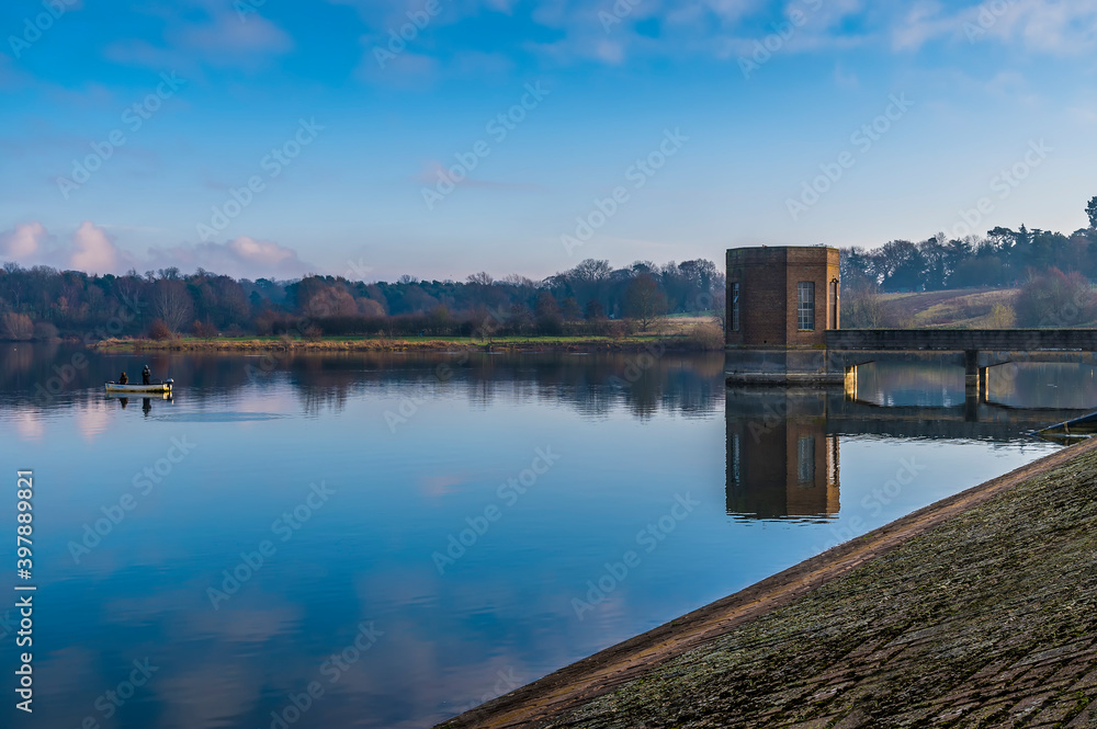 Fototapeta premium A view from the barrage of reflections along the shoreline of Pitsford Reservoir, UK in winter