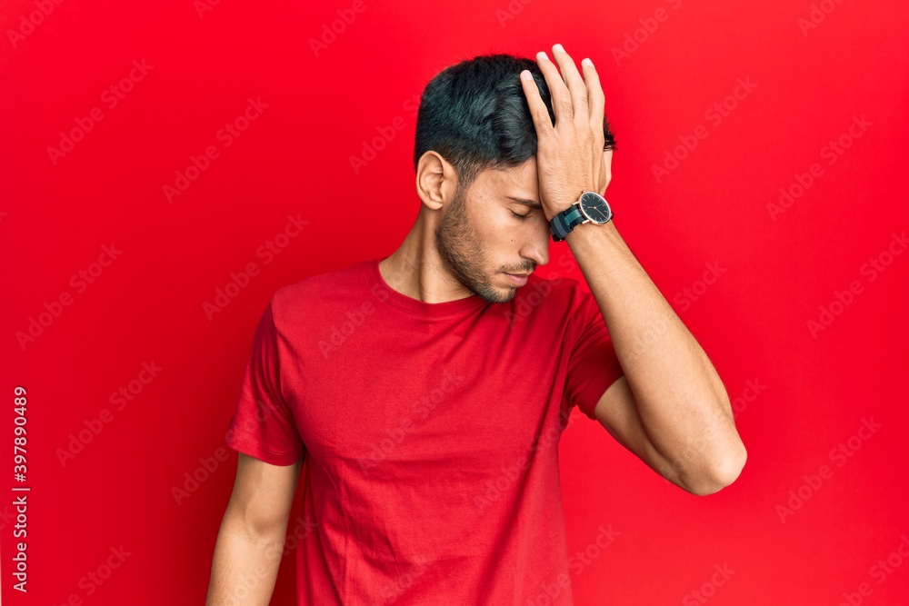 Young handsome man wearing casual tshirt over red background surprised with hand on head for mistake, remember error. forgot, bad memory concept. Young handsome man wearing casual tshirt over red background surprised with hand on head for mistake, remember error. forgot, bad memory concept.