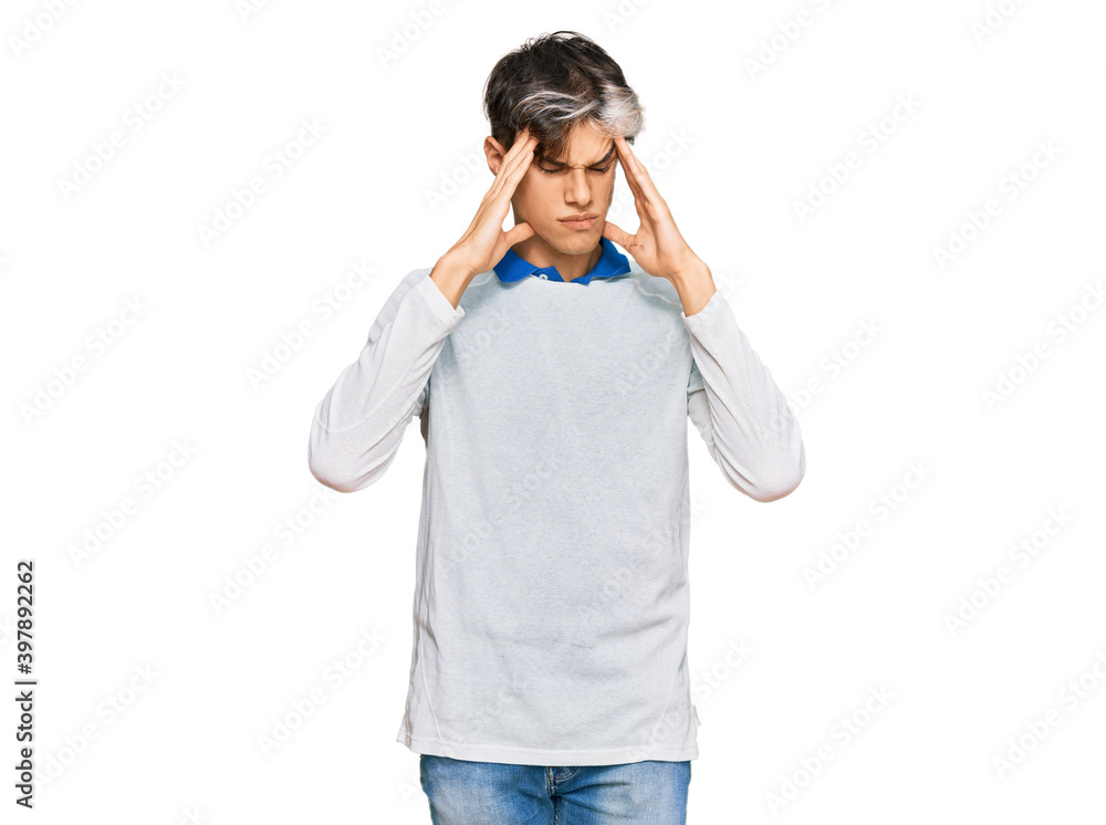 Young hispanic man wearing casual clothes with hand on head for pain in head because stress. suffering migraine. Young hispanic man wearing casual clothes with hand on head for pain in head because stress. suffering migraine.