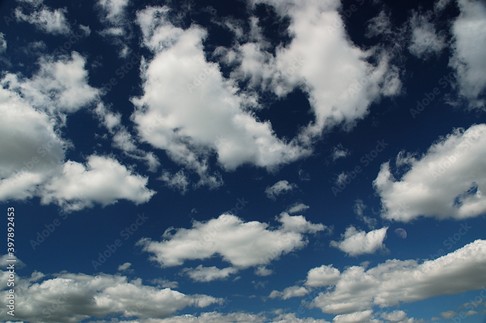 Fototapeta premium Dark blue sky with white clouds and half moon