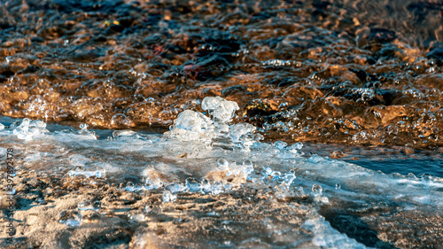 Ice forms at the water's edge in winter. Freezing river. Natural blurred background. Selective focus. photo