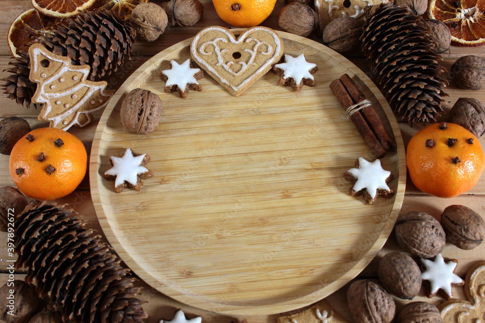 Christmas background with gingerbread, nuts, cinnamon sticks, pine cones and mandarins Christmas background with gingerbread, nuts, cinnamon sticks, pine cones and mandarins