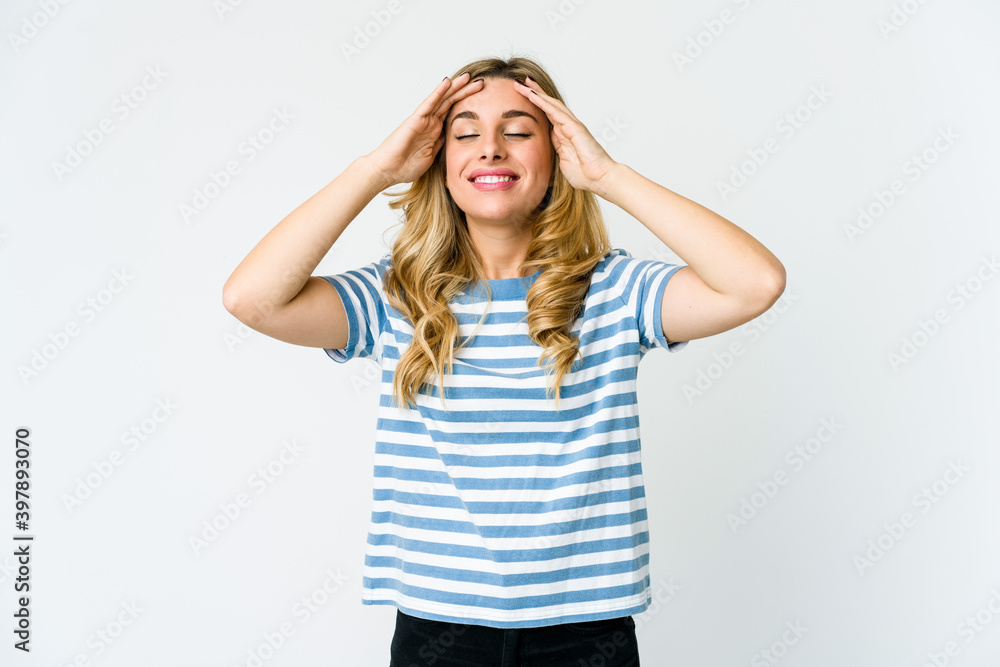 Young caucasian blonde woman laughs joyfully keeping hands on head. Happiness concept. Young caucasian blonde woman laughs joyfully keeping hands on head. Happiness concept.