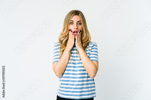 Young caucasian blonde woman shocked, covering mouth with hands, anxious to discover something new.