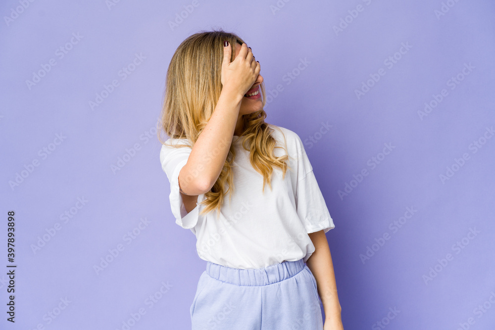 Young caucasian blonde woman covers eyes with hands, smiles broadly waiting for a surprise. Young caucasian blonde woman covers eyes with hands, smiles broadly waiting for a surprise.