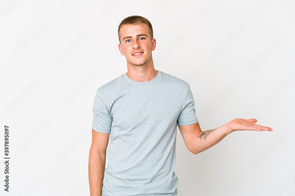Young caucasian handsome man showing a copy space on a palm and holding another hand on waist. Young caucasian handsome man showing a copy space on a palm and holding another hand on waist.