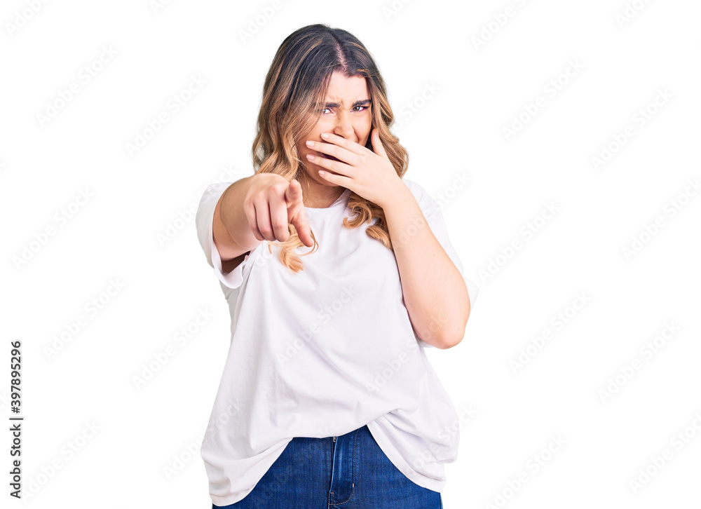 Young caucasian woman wearing casual clothes laughing at you, pointing finger to the camera with hand over mouth, shame expression Young caucasian woman wearing casual clothes laughing at you, pointing finger to the camera with hand over mouth, shame expression