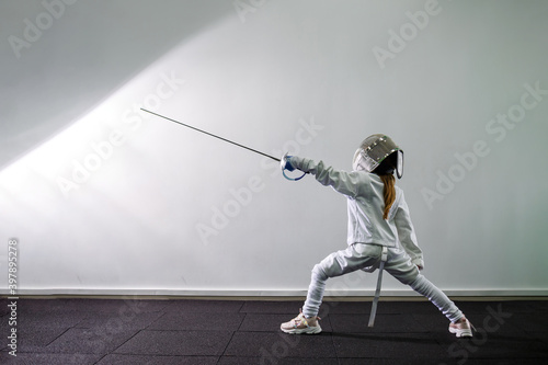 Photography Children lunge on swords. A child in a class at a fencing school
