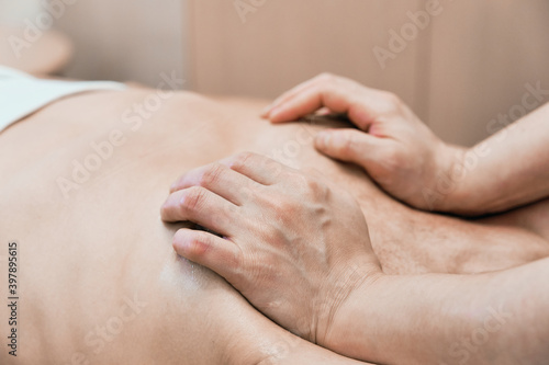 masseur makes pectoral muscles massage to his male client. sequence of elements of wellness massage and body relaxation. Chiropractor does rehabilitation procedure. Selective focus 