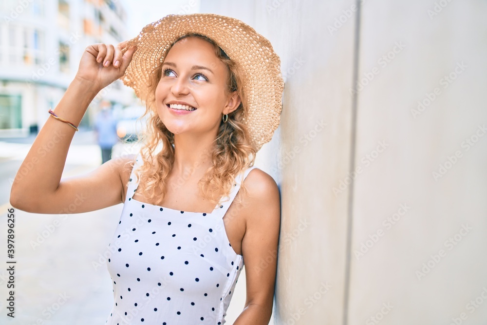 Young beautiful caucasian woman with blond hair smiling happy outdoors on a summer day
