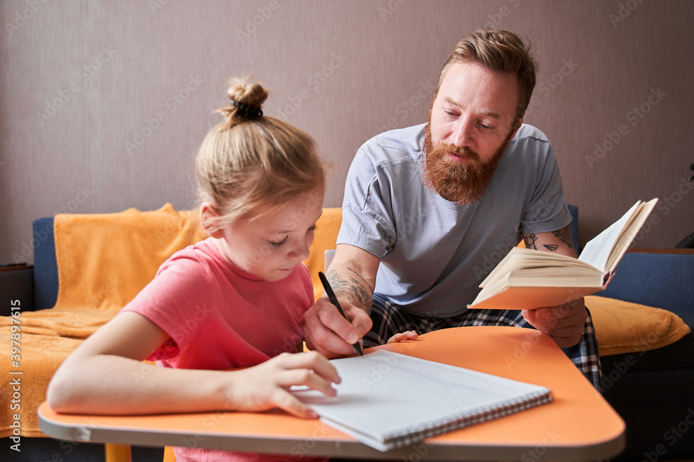 Father and little daughter sitting at desk Father and little daughter sitting at desk