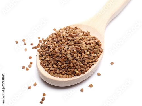 Buckwheat pile in wooden spoon isolated on white background