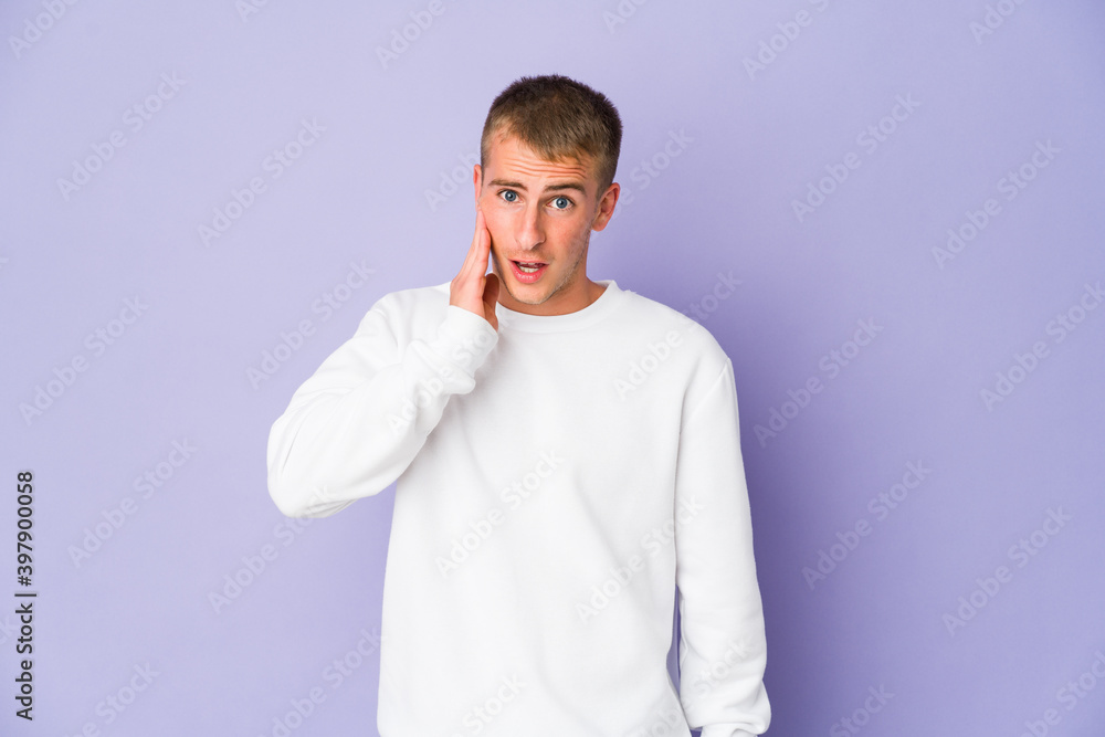 Young caucasian handsome man shouts loud, keeps eyes opened and hands tense.