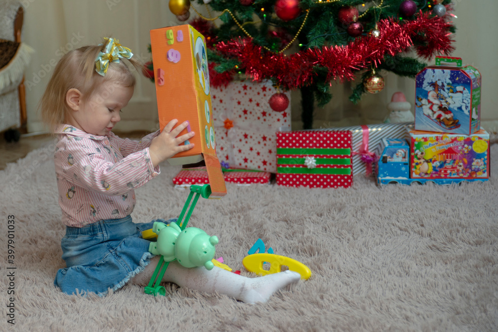 Fototapeta premium Girl opens presents Christmas