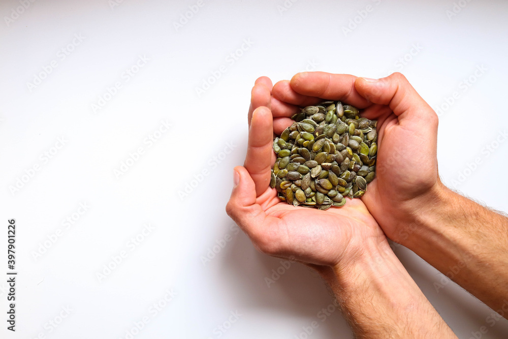Full hands of peeled pumpkin seeds with white background. Full hands of peeled pumpkin seeds with white background.