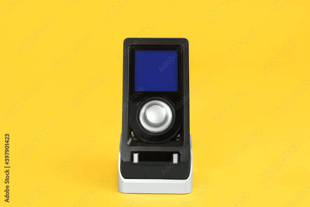 Modern remote for audio speakers on yellow background