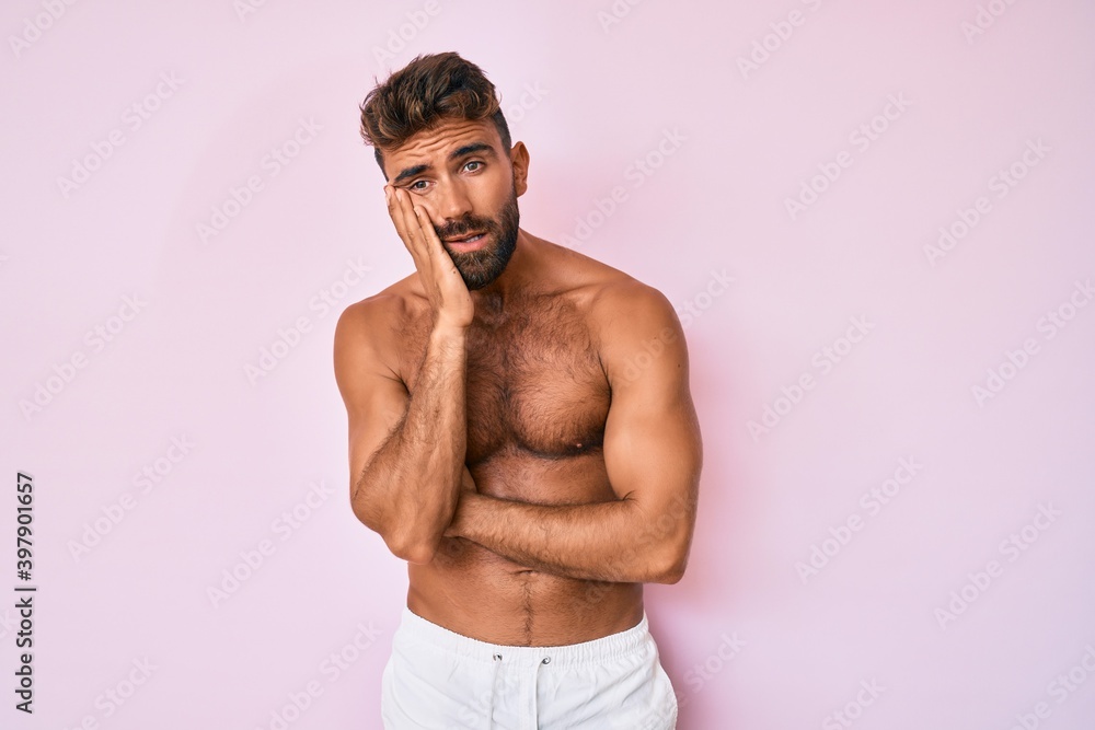Fototapeta premium Young hispanic man standing shirtless thinking looking tired and bored with depression problems with crossed arms.
