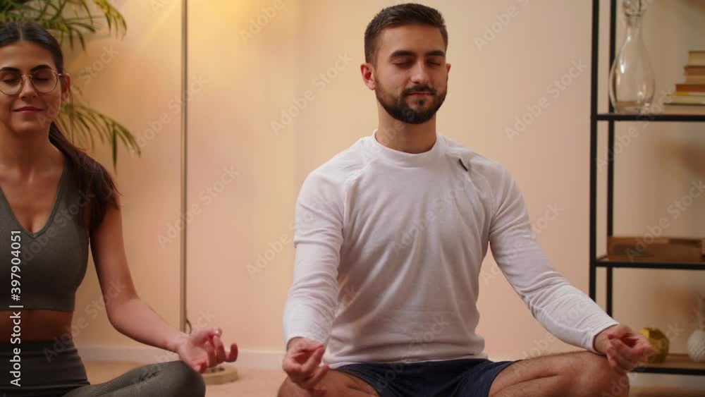 Closeup Young Caucasian Man With Woman In Sportswear Are Meditating Sitting On Yoga Mat With Closed Eyes Bright Room At Home. Stay Home Quarantine Workout Concept Of Relax And Meditation Closeup Young Caucasian Man With Woman In Sportswear Are Meditating Sitting On Yoga Mat With Closed Eyes Bright Room At Home. Stay Home Quarantine Workout Concept Of Relax And Meditation
