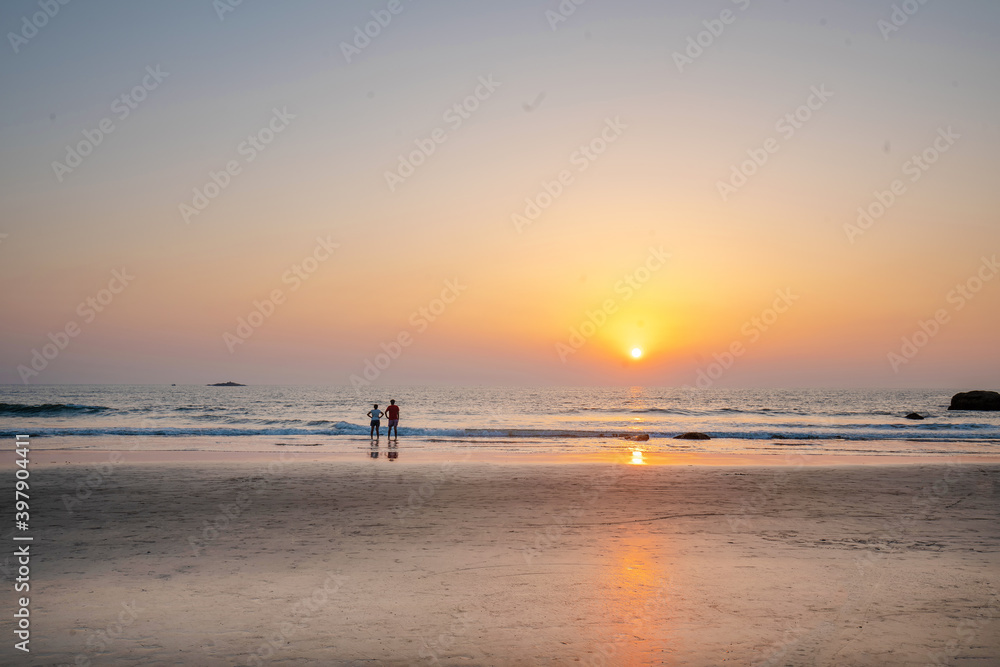Couple at distance staying and watching on  amazing sunset at South India 