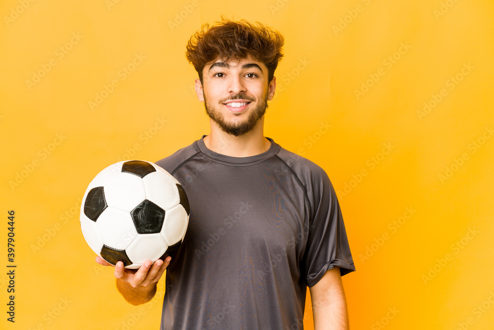 Young soccer player indian man happy, smiling and cheerful.