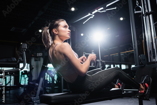 young sportswoman looking away while exercising on rowing machine in gym © LIGHTFIELD STUDIOS