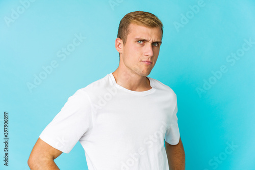 Young caucasian handsome man frowning face in displeasure, keeps arms folded.