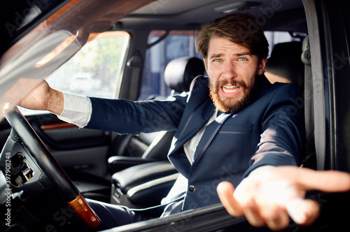 aggressive business man looking out of the car window and gesturing with his hands © SHOTPRIME STUDIO