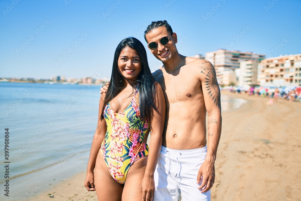 Young latin couple wearing swimwear smiling happy and hugging at the beach. Young latin couple wearing swimwear smiling happy and hugging at the beach.