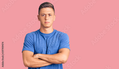 Young handsome hispanic man wearing casual clothes skeptic and nervous, disapproving expression on face with crossed arms. negative person.