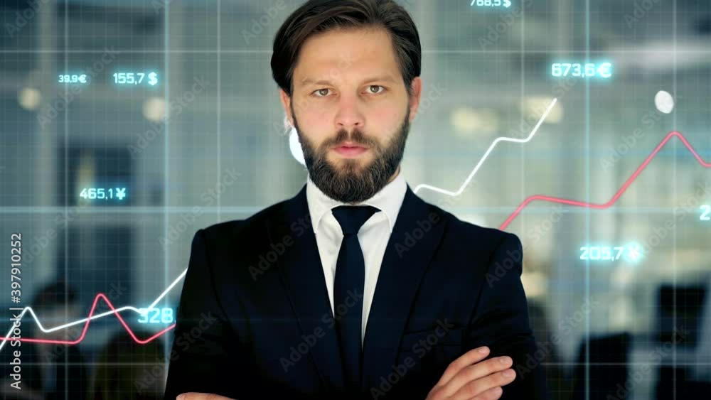 Close up of cheerful male boss with beard looking to camera. Young startup founder stands on a background of holographic graphs and tables at office room. Concept of work , business, it industry Close up of cheerful male boss with beard looking to camera. Young startup founder stands on a background of holographic graphs and tables at office room. Concept of work , business, it industry