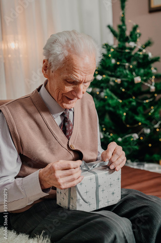 Senior Man Holding Christmas Gift in Hands on Christmas