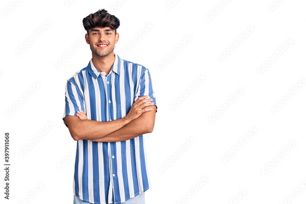 Young hispanic man wearing casual clothes happy face smiling with crossed arms looking at the camera. positive person. Young hispanic man wearing casual clothes happy face smiling with crossed arms looking at the camera. positive person.