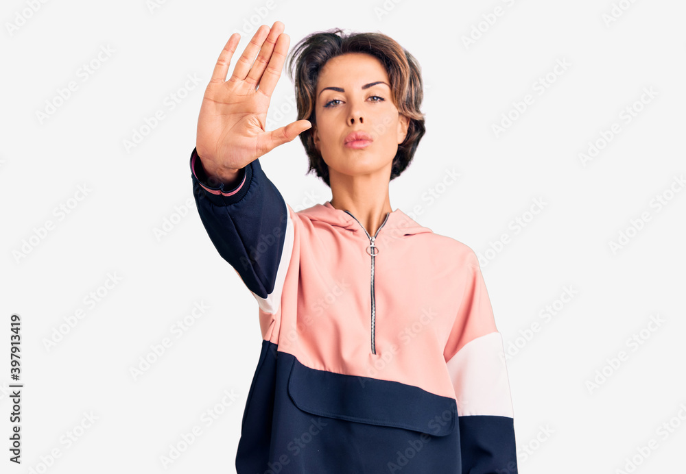 Young beautiful woman wearing sportswear doing stop sing with palm of the hand. warning expression with negative and serious gesture on the face. Young beautiful woman wearing sportswear doing stop sing with palm of the hand. warning expression with negative and serious gesture on the face.