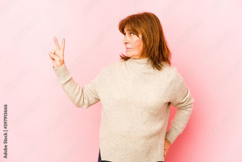 Senior caucasian woman isolated joyful and carefree showing a peace symbol with fingers. Senior caucasian woman isolated joyful and carefree showing a peace symbol with fingers.