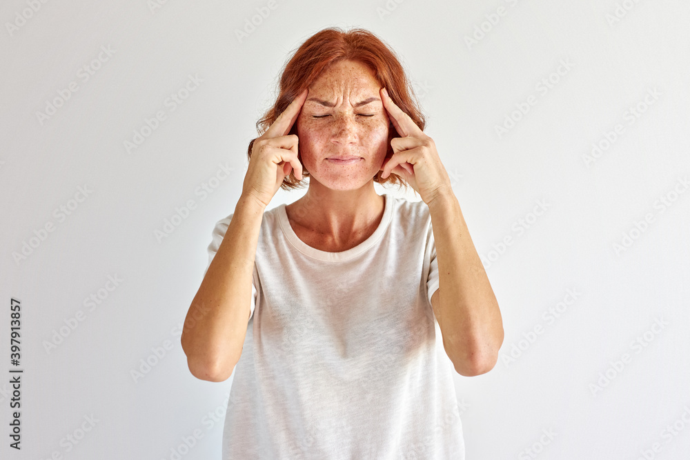 redhead woman try to remember, stand thinking, holding fingers on temple, isolated on white redhead woman try to remember, stand thinking, holding fingers on temple, isolated on white