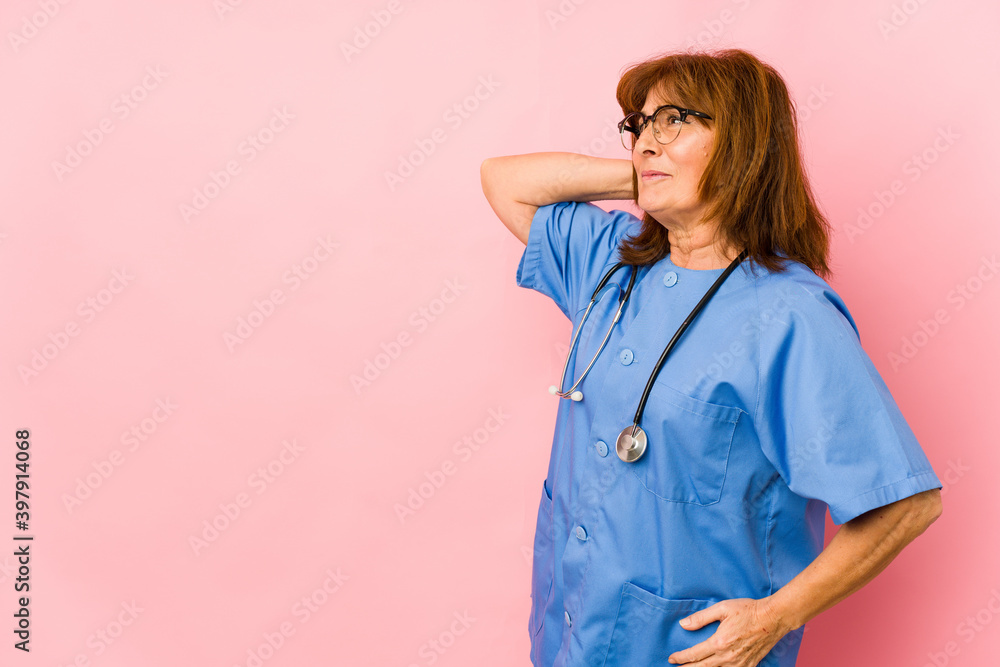 Middle age caucasian nurse woman isolated touching back of head, thinking and making a choice. Middle age caucasian nurse woman isolated touching back of head, thinking and making a choice.