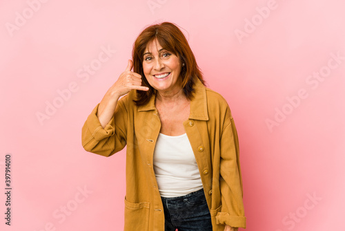 Senior caucasian woman isolated showing a mobile phone call gesture with fingers. © Asier