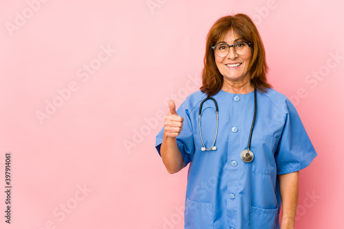 Middle age caucasian nurse woman isolated smiling and raising thumb up